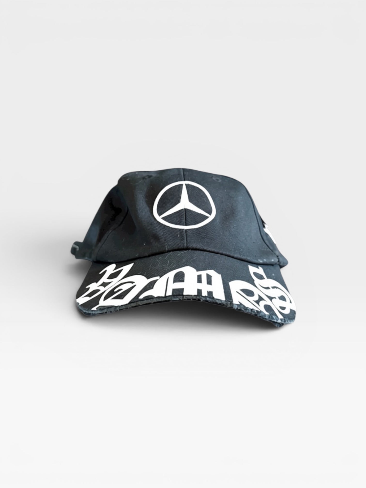 andvamos Motor Cap — distressed black cap with custom printed peak, detail view